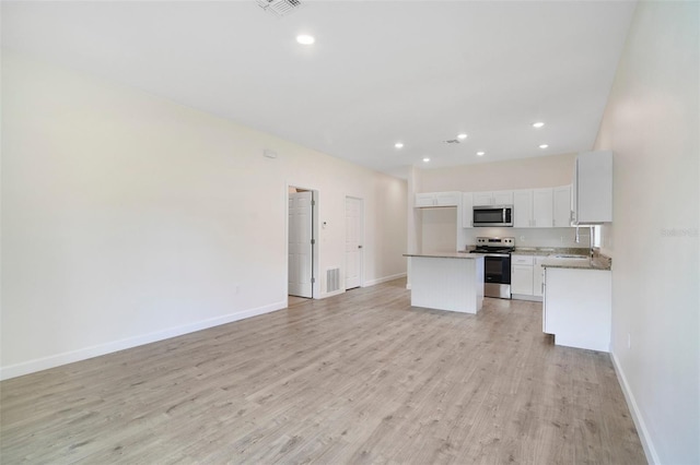 kitchen featuring white cabinetry, a center island, light wood-type flooring, sink, and appliances with stainless steel finishes