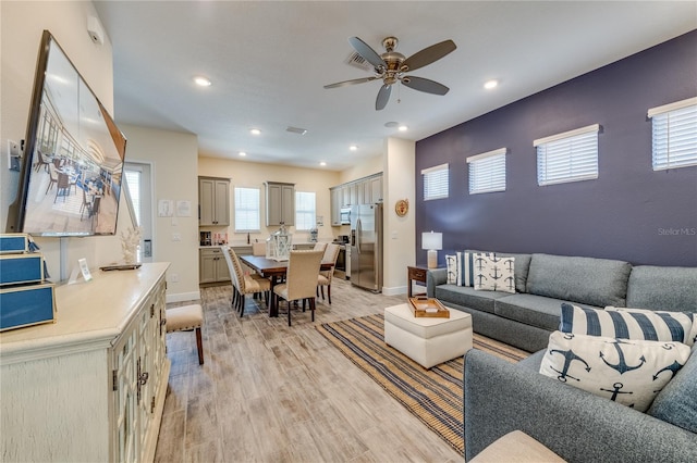 living room featuring ceiling fan and light hardwood / wood-style floors