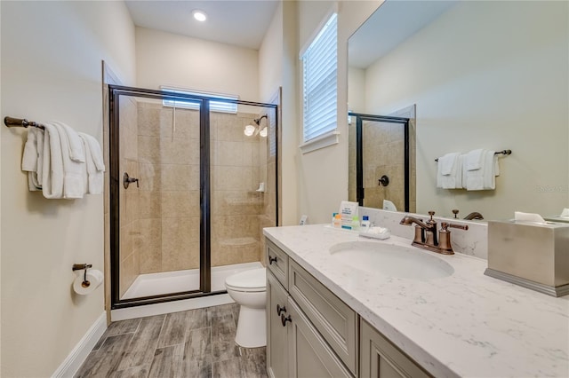 bathroom with toilet, vanity, and walk in shower