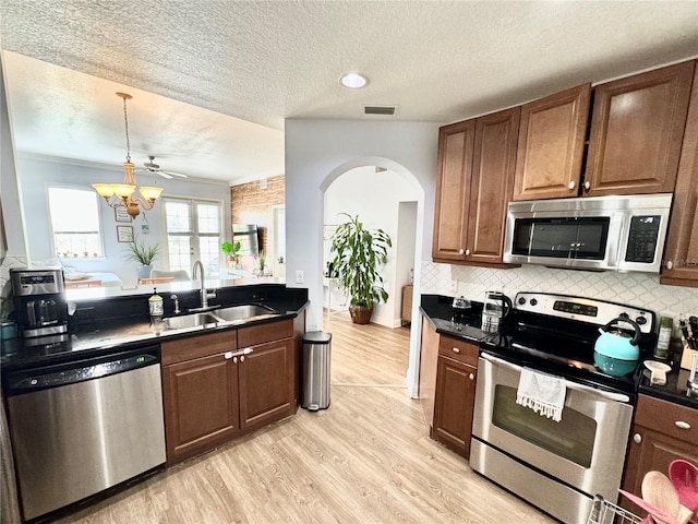 kitchen with light hardwood / wood-style floors, stainless steel appliances, a textured ceiling, ceiling fan with notable chandelier, and sink