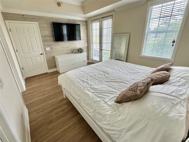 bedroom with crown molding, hardwood / wood-style floors, access to outside, and multiple windows