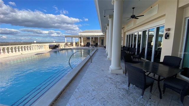 view of pool with ceiling fan, a water view, and a patio