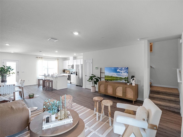 living room featuring a textured ceiling and dark hardwood / wood-style floors