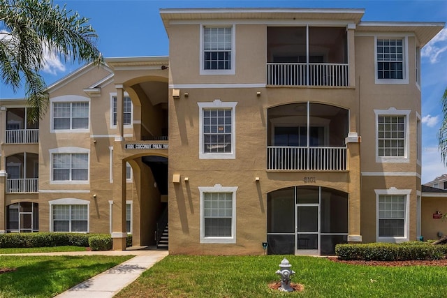 view of front of property featuring a balcony and a front yard