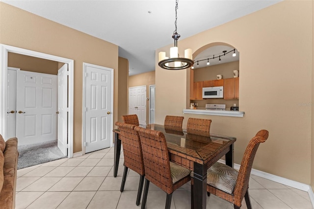 tiled dining room with a notable chandelier