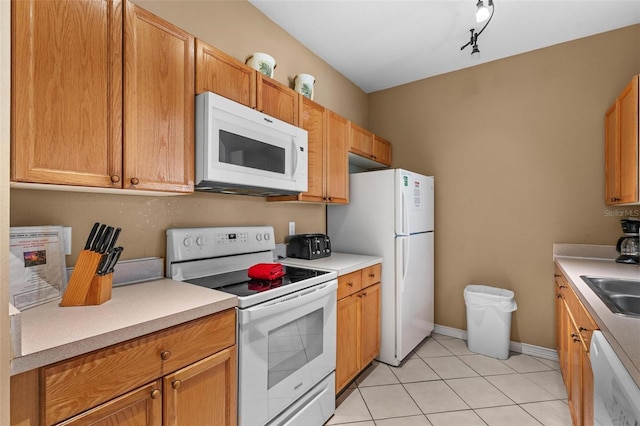 kitchen with light tile patterned flooring, sink, and white appliances