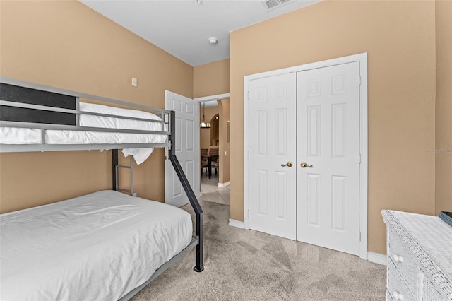 bedroom featuring light colored carpet and a closet