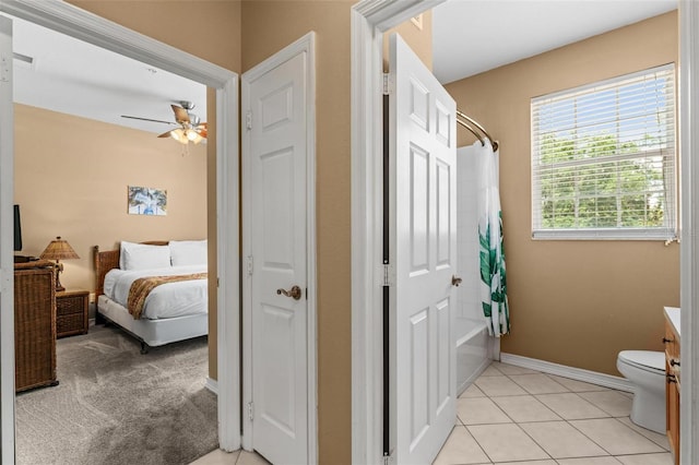 full bathroom with shower / bath combination with curtain, vanity, ceiling fan, toilet, and tile patterned floors