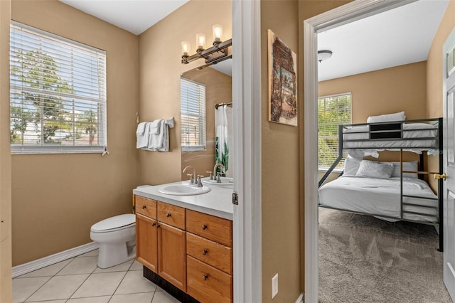 bathroom featuring vanity, tile patterned flooring, a wealth of natural light, and toilet