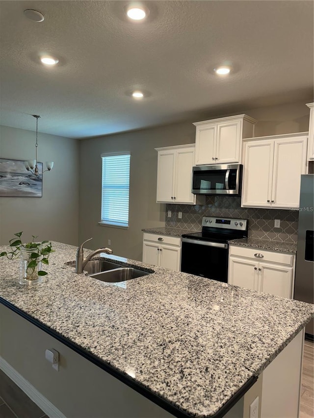 kitchen featuring wood-type flooring, sink, white cabinetry, and stainless steel appliances