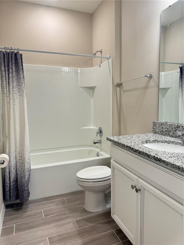 full bathroom featuring hardwood / wood-style floors, vanity, shower / bath combo, and toilet