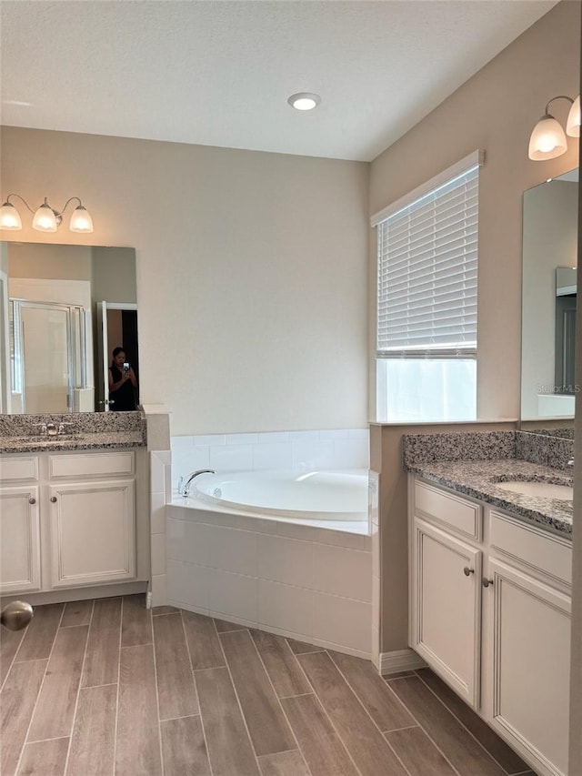 bathroom featuring hardwood / wood-style floors, vanity, and separate shower and tub