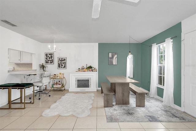 tiled dining area featuring a chandelier and a textured ceiling