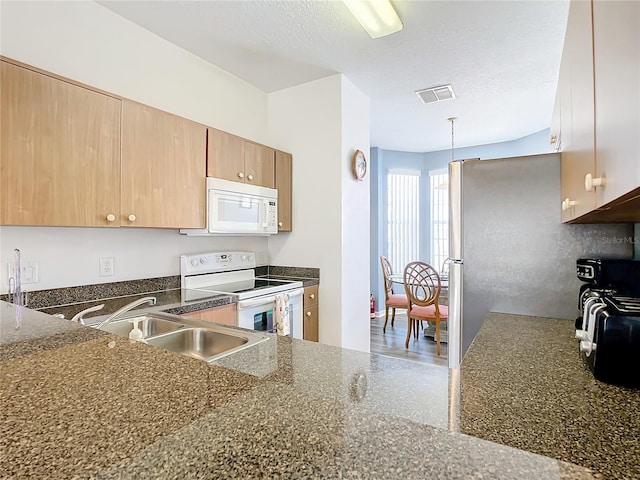 kitchen featuring a textured ceiling, sink, pendant lighting, and white appliances