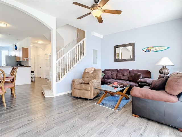 living room with ceiling fan, light hardwood / wood-style floors, and electric panel