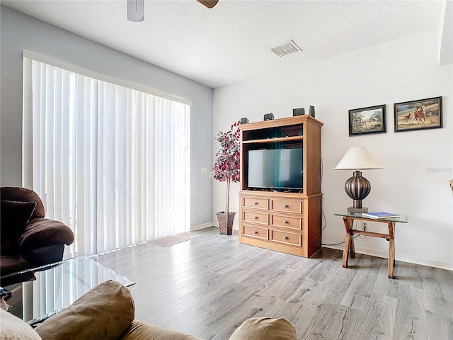 living room with ceiling fan and light wood-type flooring