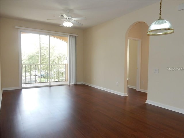 unfurnished room with ceiling fan and dark hardwood / wood-style flooring