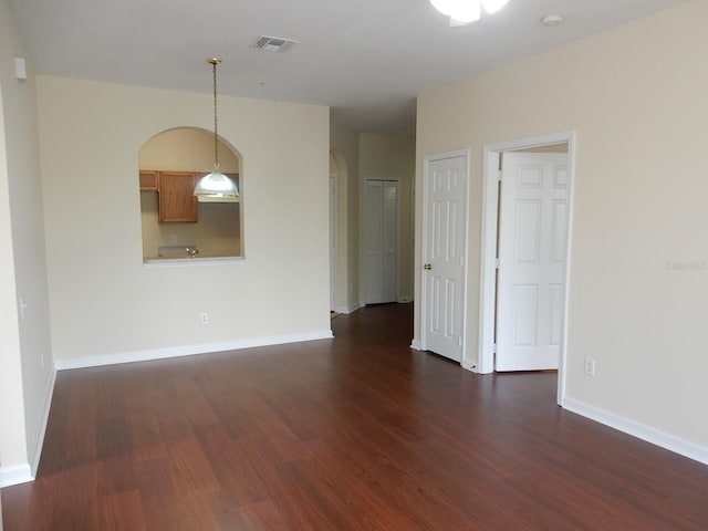 empty room with dark hardwood / wood-style flooring