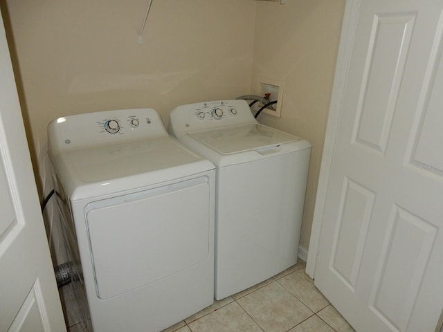 washroom with light tile patterned floors and washer and dryer