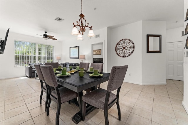 tiled dining area with ceiling fan with notable chandelier