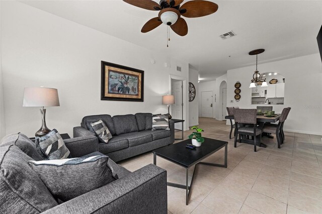 living room with ceiling fan with notable chandelier and light tile floors