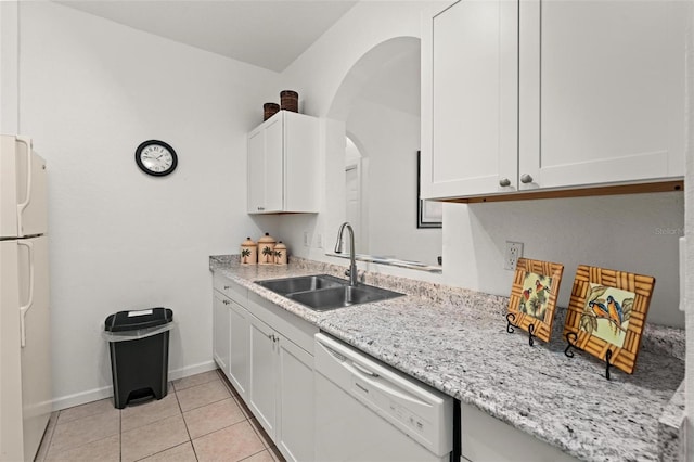 kitchen with light stone counters, white cabinets, sink, white appliances, and light tile floors