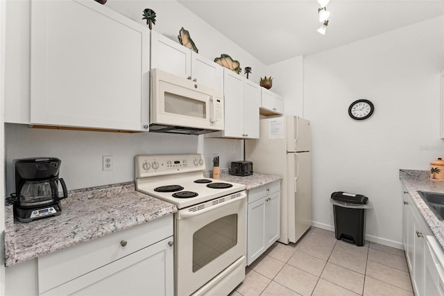 kitchen featuring light stone countertops, white appliances, white cabinets, sink, and light tile floors