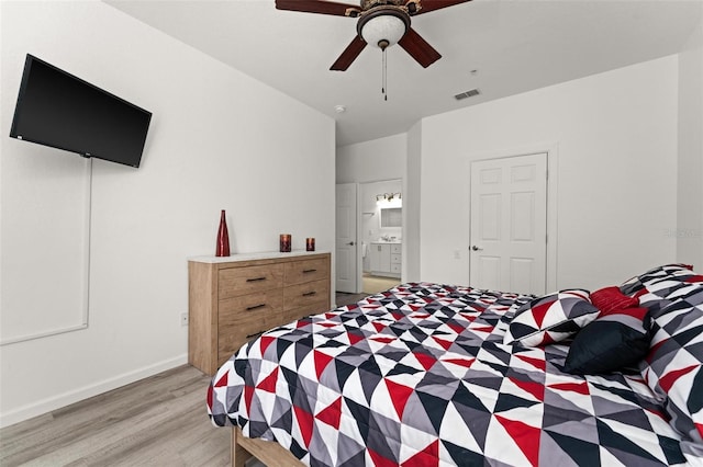 bedroom with light hardwood / wood-style floors, connected bathroom, and ceiling fan