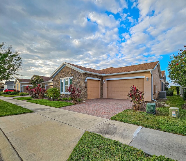 ranch-style house with a garage, central AC, and a front yard