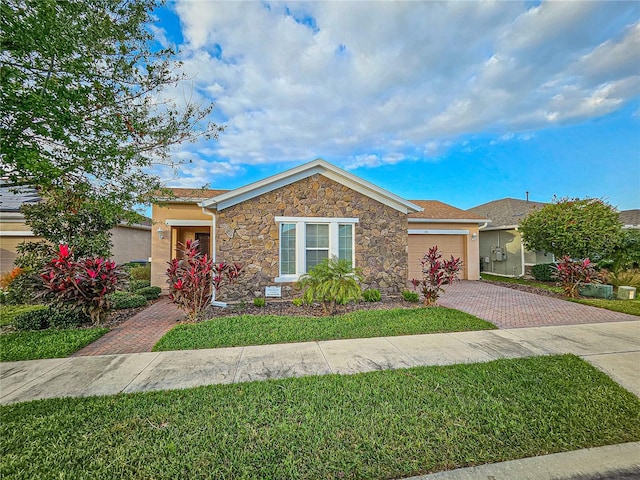 single story home with a garage and a front lawn