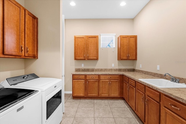 laundry area featuring sink, cabinets, washing machine and clothes dryer, and light tile patterned flooring