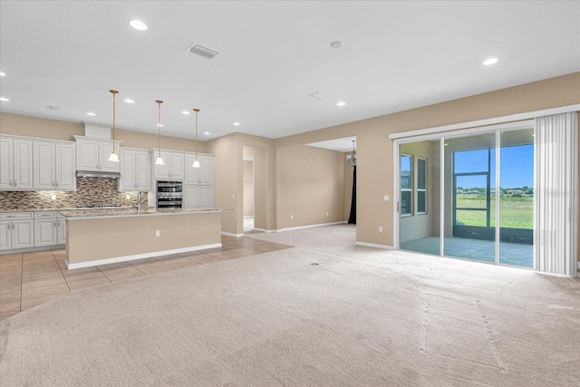 unfurnished living room with light tile patterned floors and sink