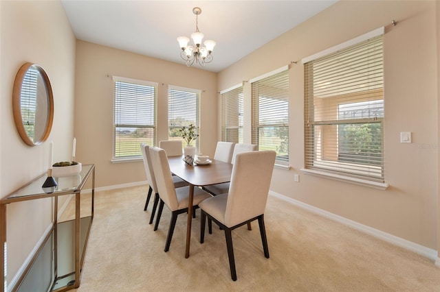 dining space with light colored carpet and a chandelier