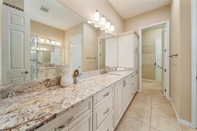 bathroom with tile patterned flooring, vanity, and a shower with shower door