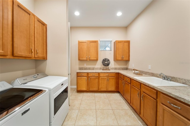 laundry area with sink, cabinets, light tile patterned floors, and independent washer and dryer