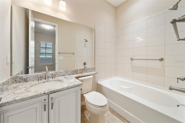 full bathroom featuring vanity, tiled shower / bath, tile patterned flooring, and toilet