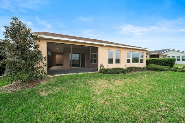 back of property featuring a sunroom and a lawn