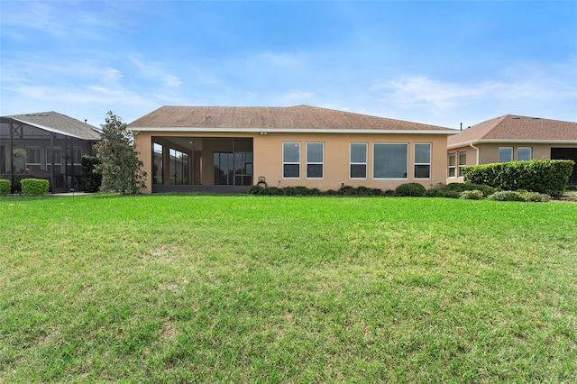 rear view of house with a sunroom and a lawn