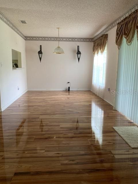 spare room featuring dark hardwood / wood-style flooring and a textured ceiling