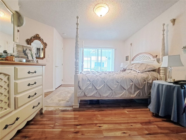 bedroom with wood-type flooring and a textured ceiling