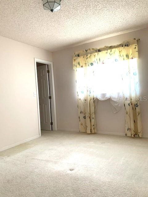 carpeted spare room featuring a textured ceiling