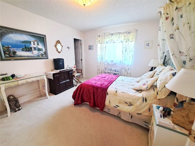 bedroom with a textured ceiling and light carpet