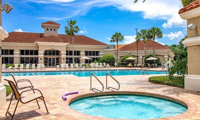 view of swimming pool featuring a patio and a hot tub