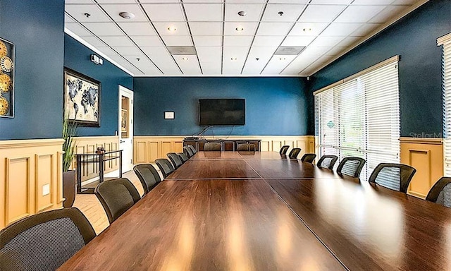 dining area with wood-type flooring and a paneled ceiling