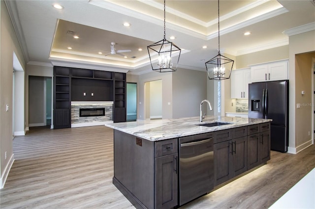 kitchen with white cabinets, a tray ceiling, light wood-type flooring, and ceiling fan with notable chandelier