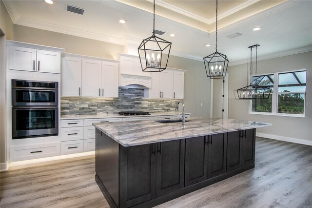 17694 SW 61st Lane Rd, Dunnellon, FL 34432 - kitchen with a sink, a chandelier, black gas cooktop, backsplash, and a kitchen island with sink