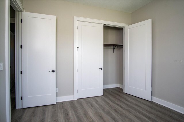 17694 SW 61st Lane Rd, Dunnellon, FL 34432 - unfurnished bedroom with wood finished floors, a closet, and baseboards