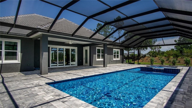 view of pool with glass enclosure, an in ground hot tub, a patio area, and ceiling fan