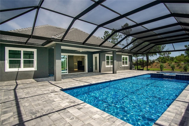 view of pool featuring a patio area, glass enclosure, and ceiling fan