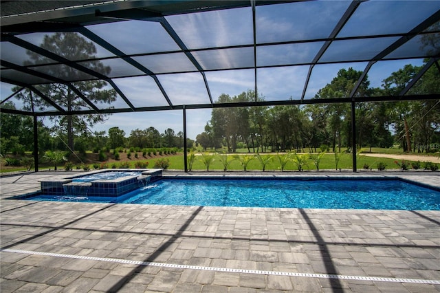 view of pool with a patio area, pool water feature, a lanai, and an in ground hot tub